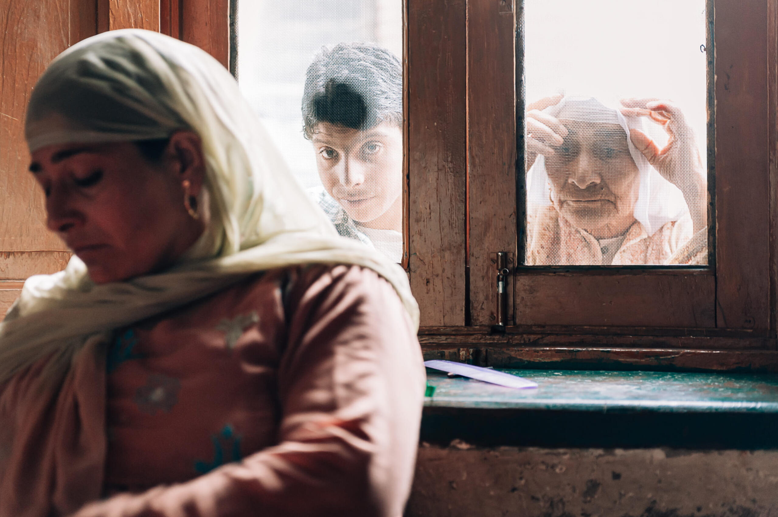 Peering into her room are her son, Fazil, and her mother-in-law, Rathe